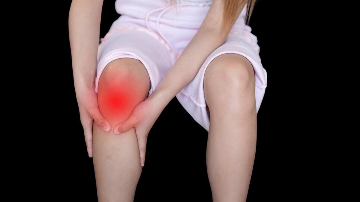 Athlete massaging RecoverMaxX recovery oil into calf after a run